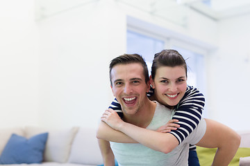 Image showing handsome man piggybacking his girlfriend