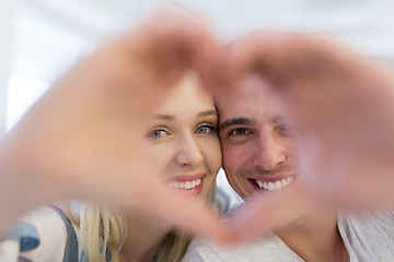 Image showing couple making heart with hands