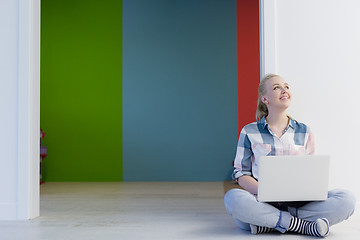 Image showing young woman using laptop computer on the floor