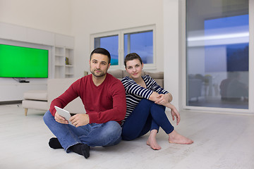 Image showing Young Couple using digital tablet on the floor