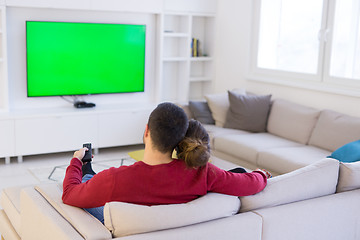 Image showing Young couple on the sofa watching television