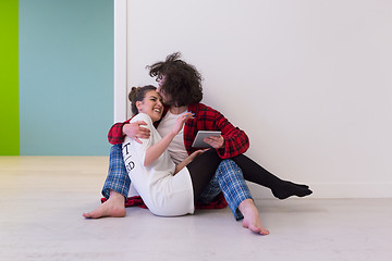 Image showing Young Couple using digital tablet on the floor