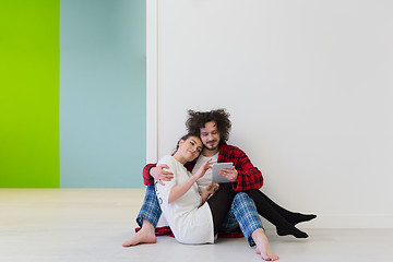 Image showing Young Couple using digital tablet on the floor