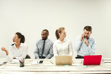 Image showing Young men and women sitting at office and working on laptops. Emotions concept