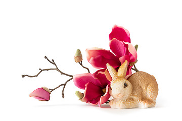 Image showing easter bunny sitting by some red magnolia flowers