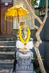 Image showing Garland of golden flowers draped around Ganesha