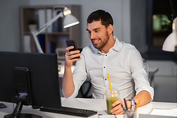 Image showing businessman with smartphone at night office