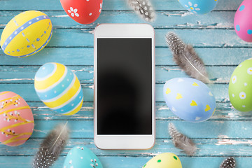 Image showing smartphone with easter eggs and quail feathers