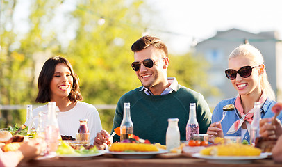 Image showing happy friends eating and drinking at rooftop party