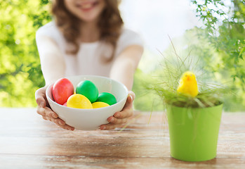 Image showing close up of girl with bowl of colored easter eggs