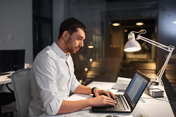 Image showing businessman with laptop working at night office