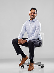 Image showing smiling indian businessman sitting on office chair