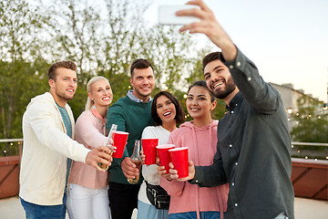 Image showing friends with drinks taking selfie at rooftop party