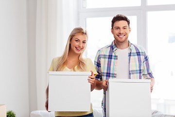 Image showing happy couple with boxes moving to new home