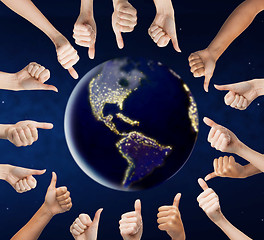 Image showing human hands showing thumbs up around earth planet