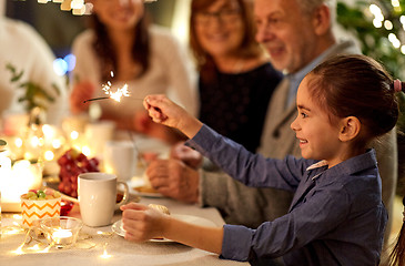 Image showing happy girl with sparkler at family tea party