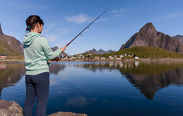 Image showing Woman fishing on Fishing rod spinning in Norway.