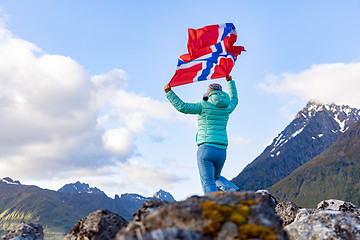 Image showing Woman with a waving flag of Norway on the background of nature