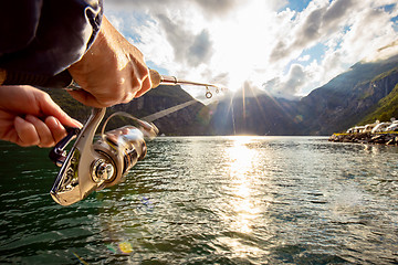 Image showing Woman fishing on Fishing rod spinning in Norway.