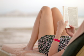 Image showing Woman reading book on the beach