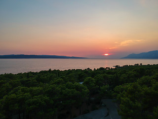 Image showing An aerial view from drone to the trees and sunset over sea