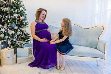 Image showing Beautiful pregnant woman in ultra violet dress sitting with doughter
