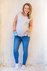 Image showing Beautiful pregnant woman standing near wall