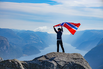 Image showing Woman with a waving flag of Norway on the background of nature