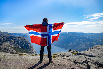 Image showing Woman with a waving flag of Norway on the background of nature