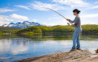 Image showing Woman fishing on Fishing rod spinning in Norway.