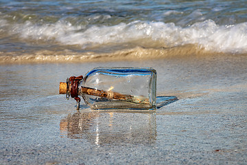 Image showing Message in the bottle against the Sun setting down