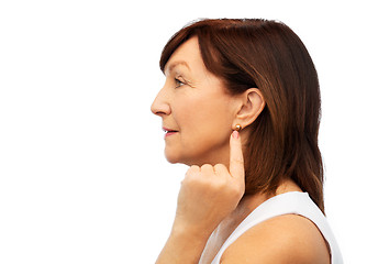 Image showing senior woman pointing to her golden earring