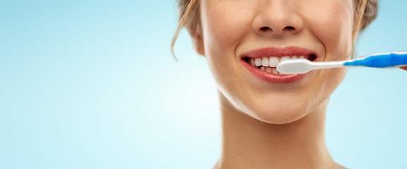 Image showing close up of woman with toothbrush cleaning teeth