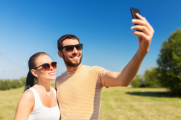 Image showing happy couple taking selfie by smartphone in summer