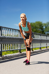 Image showing young woman with knee support brace on leg