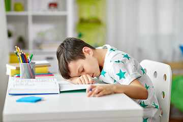 Image showing tired student boy sleeping on table at home