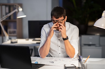 Image showing tired businessman working at night office
