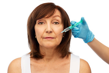 Image showing senior woman and surgeon hand with syringe