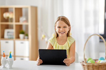 Image showing happy girl with tablet pc and easter eggs at home