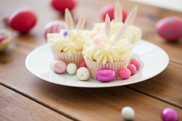 Image showing cupcakes with easter eggs and candies on table