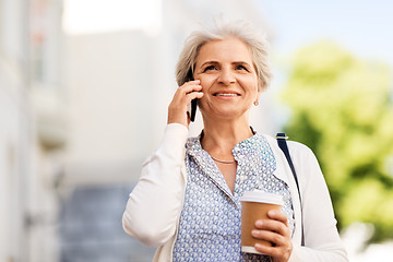 Image showing senior woman calling on smartphone in city