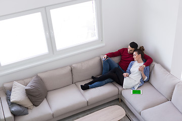 Image showing Young couple on the sofa watching television