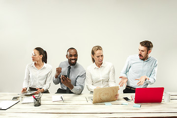 Image showing Young men and women sitting at office and working on laptops. Emotions concept