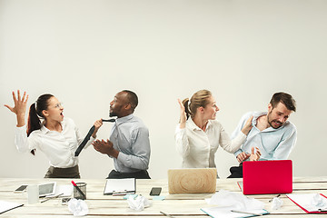 Image showing Young men and women sitting at office and working on laptops. Emotions concept