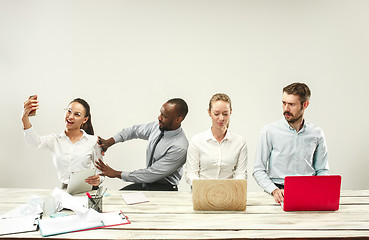 Image showing Young men and women sitting at office and working on laptops. Emotions concept