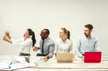 Image showing Young men and women sitting at office and working on laptops. Emotions concept