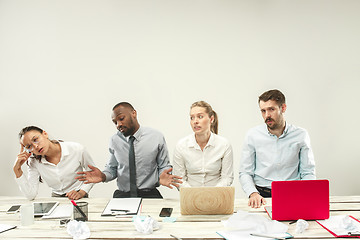 Image showing Young men and women sitting at office and working on laptops. Emotions concept