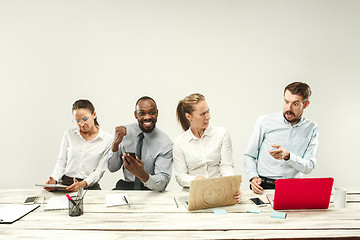 Image showing Young men and women sitting at office and working on laptops. Emotions concept