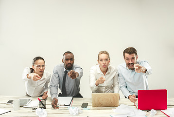 Image showing Young men and women sitting at office and working on laptops. Emotions concept