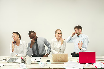 Image showing Young men and women sitting at office and working on laptops. Emotions concept